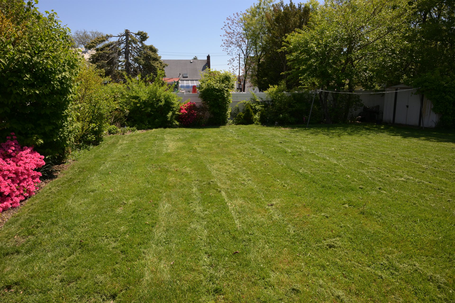 Finished residential backyard with cleanly mowed lawn and trimmed beds