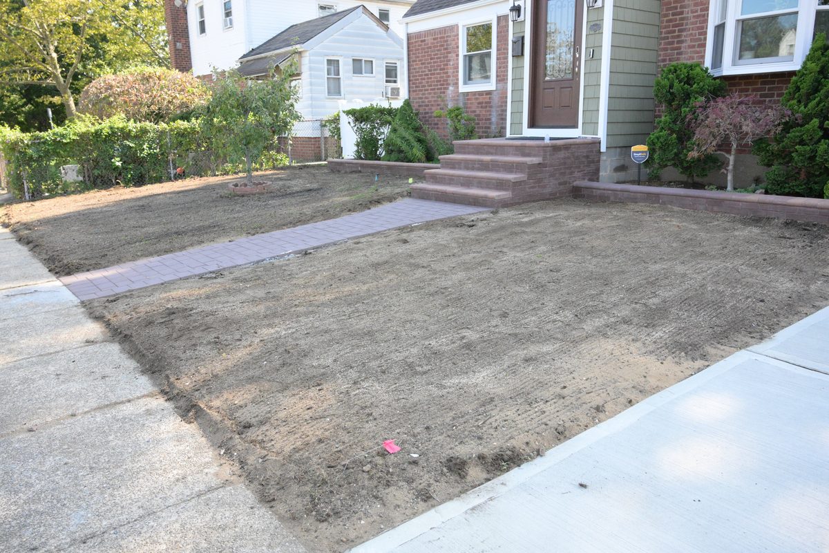 Lot clearing with fresh soil and brick walkway