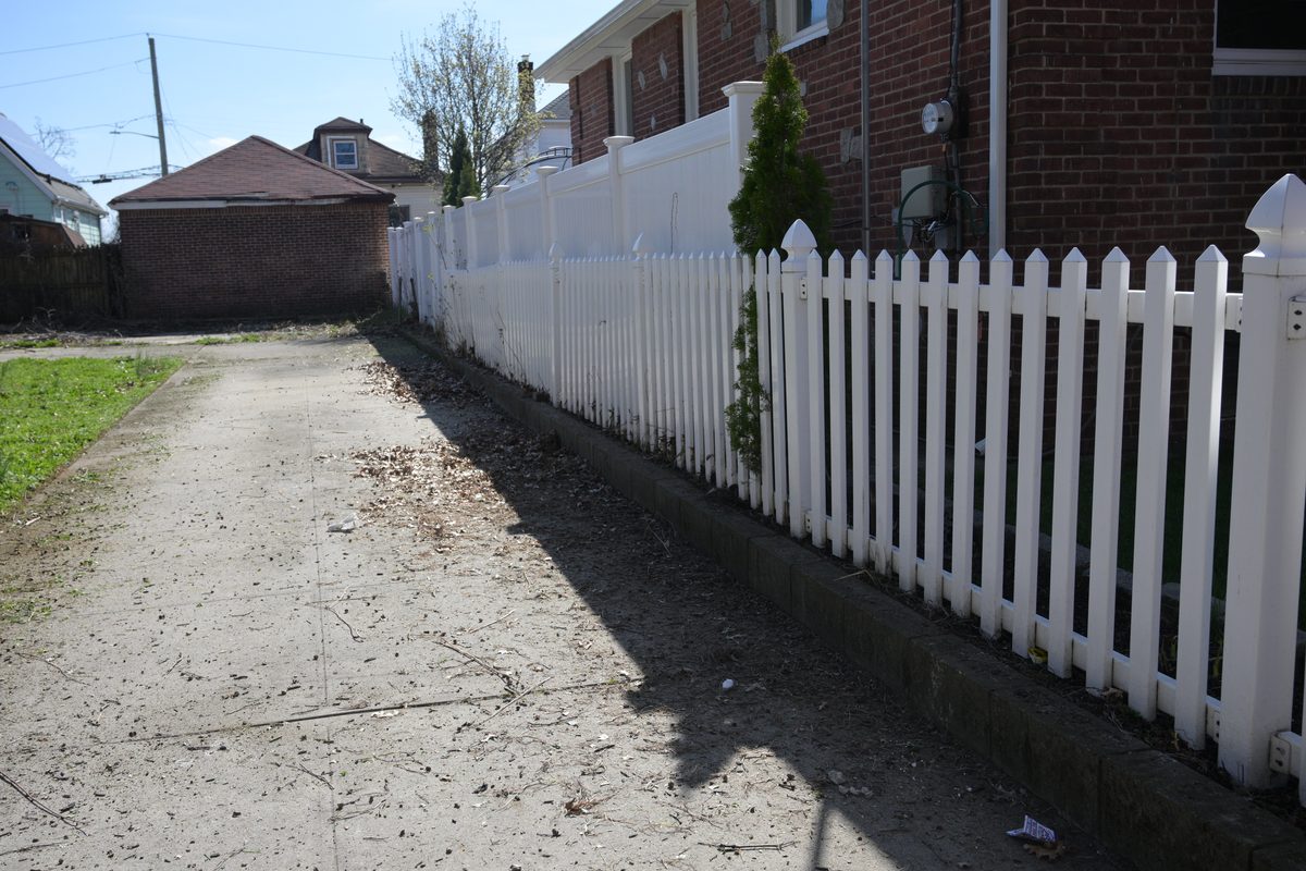 Clean walkway along white picket fence